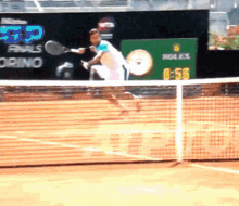 a tennis player is swinging a racket on a court with a rolex advertisement in the background