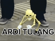 a person is standing next to a skeleton that says ardi tulang