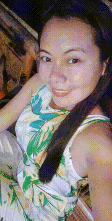 a woman in a floral dress is smiling and looking at the camera