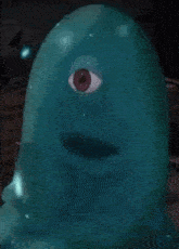a close up of a blue monster with a red eye on its face .