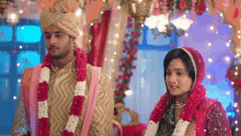 a bride and groom standing next to each other in a room decorated with flowers