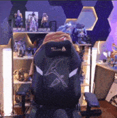 a black gaming chair with a sword on the back of it