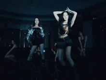a woman in a pleated skirt is dancing in a dark room with other women