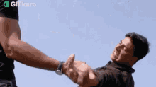 a man is holding another man 's hand while giving a high five .