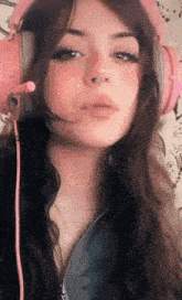 a girl wearing pink headphones and a nose ring .