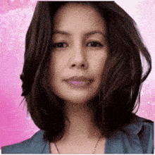 a woman with long hair is wearing a blue jacket and a necklace .
