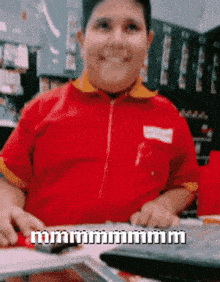 a man in a red shirt is sitting at a table with a keyboard and a calculator