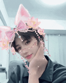 a girl wearing a headband with pink flowers and bows on it
