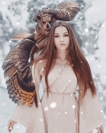 a woman standing in the snow with an owl on her shoulders