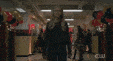 a woman is screaming in a hallway with balloons and a cw logo