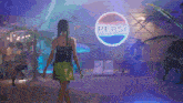 a woman walking in front of a pepsi logo