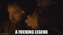 a man with a beard is talking to a woman with the words " a fucking legend " on the bottom