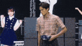 a man in a plaid shirt holds a belt that says ' sn ' on it