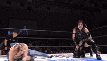two women wrestling in a ring with a referee wearing a shirt that says ' tokyo ' on it