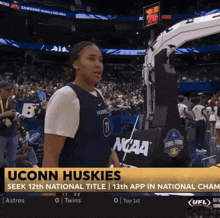a uconn huskies basketball player stands in front of a large crowd
