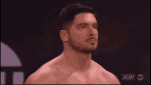 a shirtless man is standing in front of a sign that says aew tnt