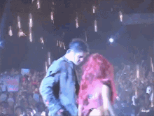 a man and a woman are dancing on a stage in front of a crowd with a rbd.gif written on the bottom