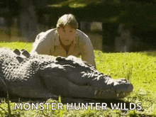 a man is laying on top of a crocodile in the grass .