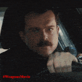 a person walking down a street with #weaponsmovie on the bottom right