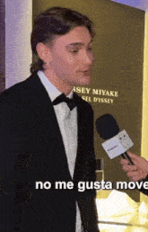 a man in a tuxedo is being interviewed by someone with a microphone that says " no me gusta move " on it