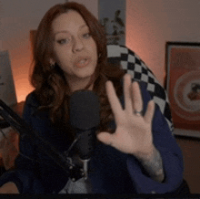 a woman sitting in front of a microphone making a funny face
