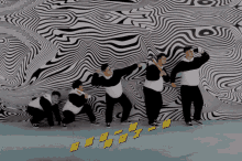 a group of people are dancing in front of a wall that has chinese writing on it