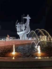a fountain with a statue of a man riding a dolphin in it
