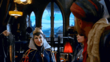 a woman in a crown is talking to a man and another woman