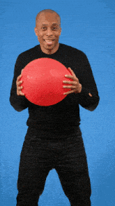a man in a black shirt holds a red balloon in his hands