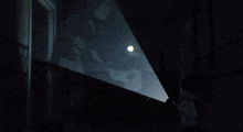 a person is standing in a dark room with a glowing circle in front of them