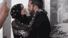 a man and a woman are kissing in front of a mirror