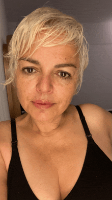 a woman with short blonde hair is wearing a bra