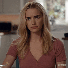 a woman sitting at a table with a netflix logo on her sleeve