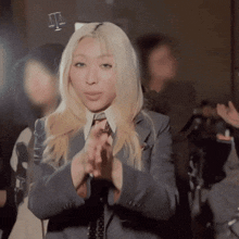 a blonde woman in a suit and tie is making a funny face