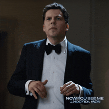 a man in a tuxedo and bow tie is holding a piece of ice in his hand