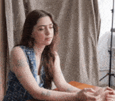 a woman sitting at a table with her eyes closed
