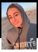 a girl wearing a hoodie that says nike knights on it