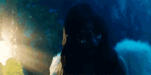 a close up of a person 's face in a dark room with a blue background