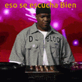 a man wearing a shirt that says d-block stands in front of a mixer