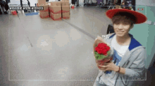 a man wearing a red hat is holding a bouquet of roses