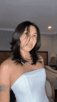 a woman in a white strapless corset is standing in a room