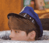 a young man is wearing a police hat and sunglasses while sitting in a trash can .
