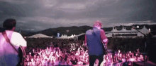 a man playing a guitar in front of a crowd