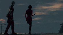 a man and a woman are walking on a rooftop at night .