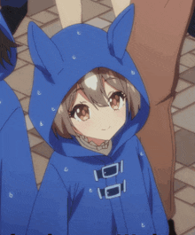 a little girl wearing a blue hoodie with bunny ears on it
