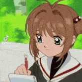 a girl is writing on a piece of paper with a red pen .