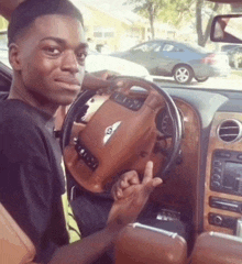 a man is sitting in the driver 's seat of a brown bentley car