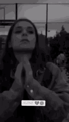 a black and white photo of a woman with the word alone on the bottom right