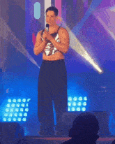 a man stands on stage holding a microphone