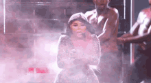 a woman in a dress is dancing on a stage with a group of men .
